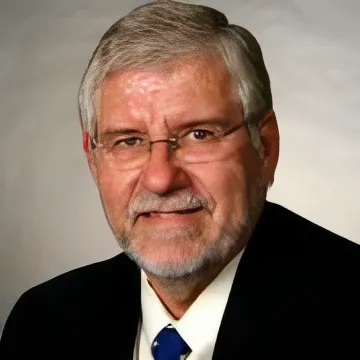 Portrait of Larry Jeffus, smiling, in a dark jacket and blue tie.